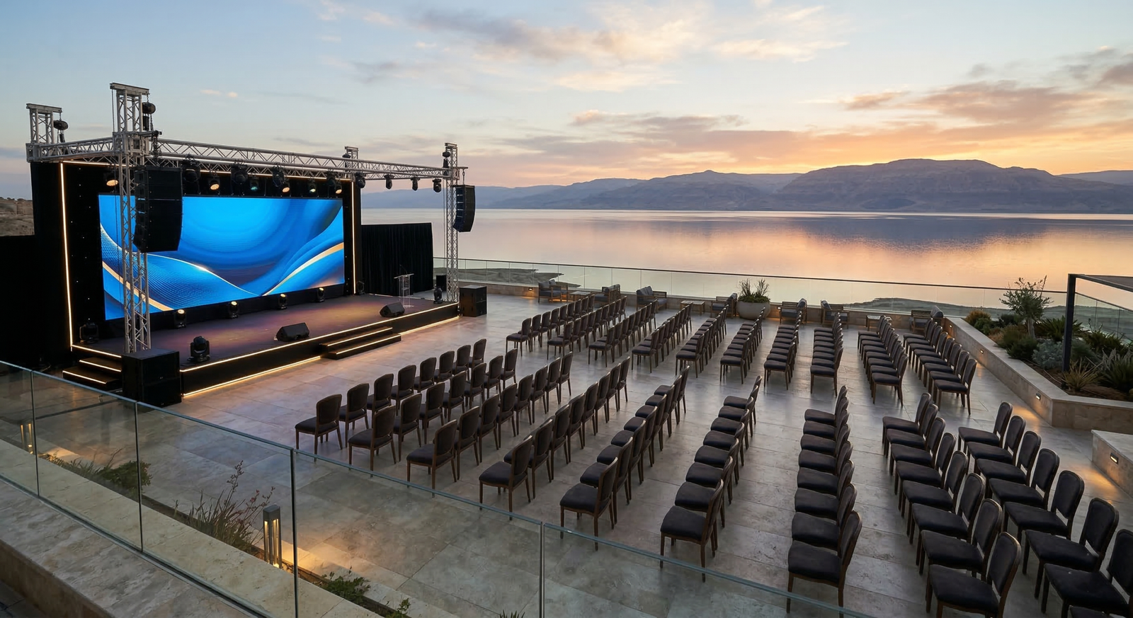 High-end strategic setup for dead sea corporate events featuring an outdoor stage and seating overlooking the water