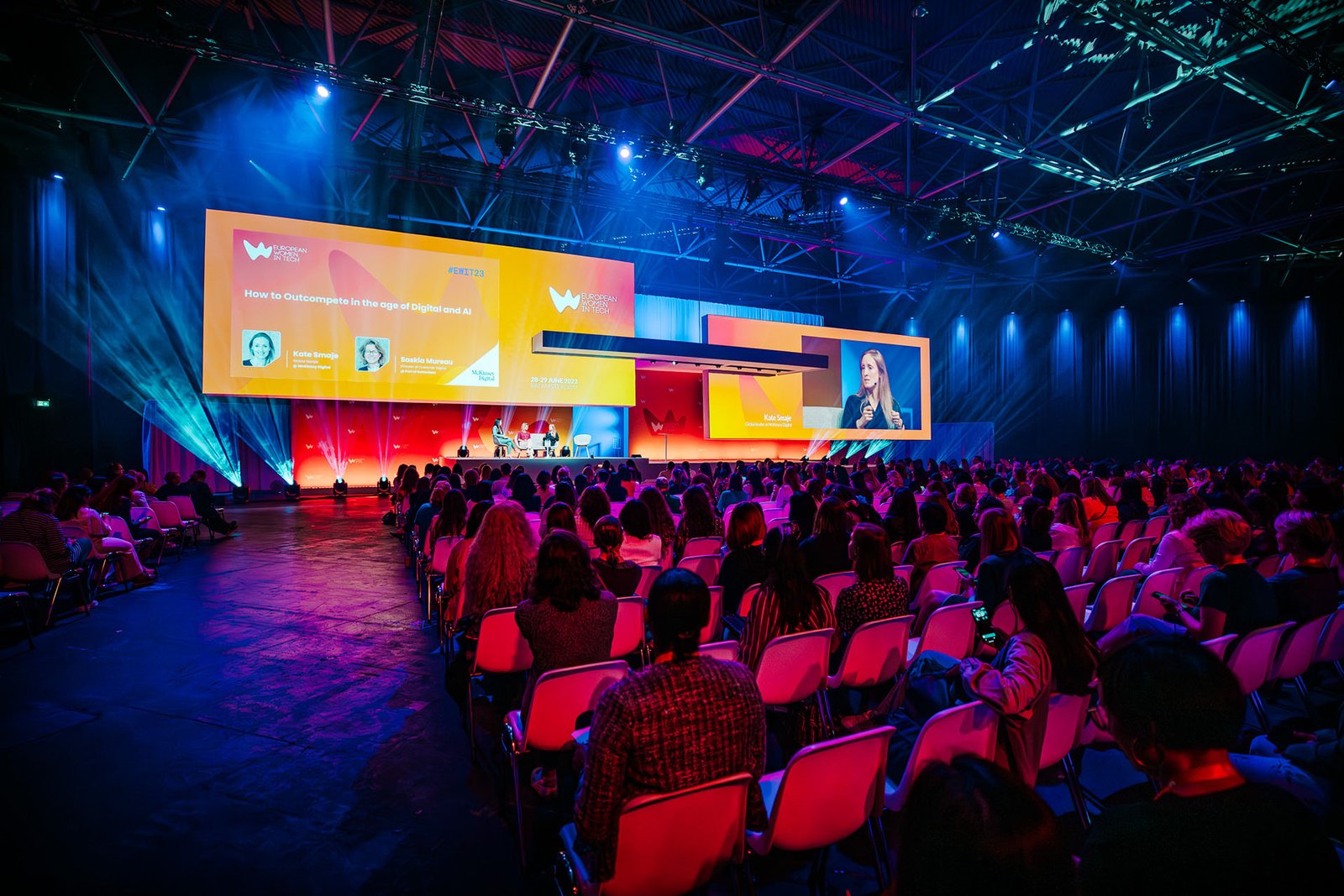 Corporate conference event with speakers on stage and audience seating